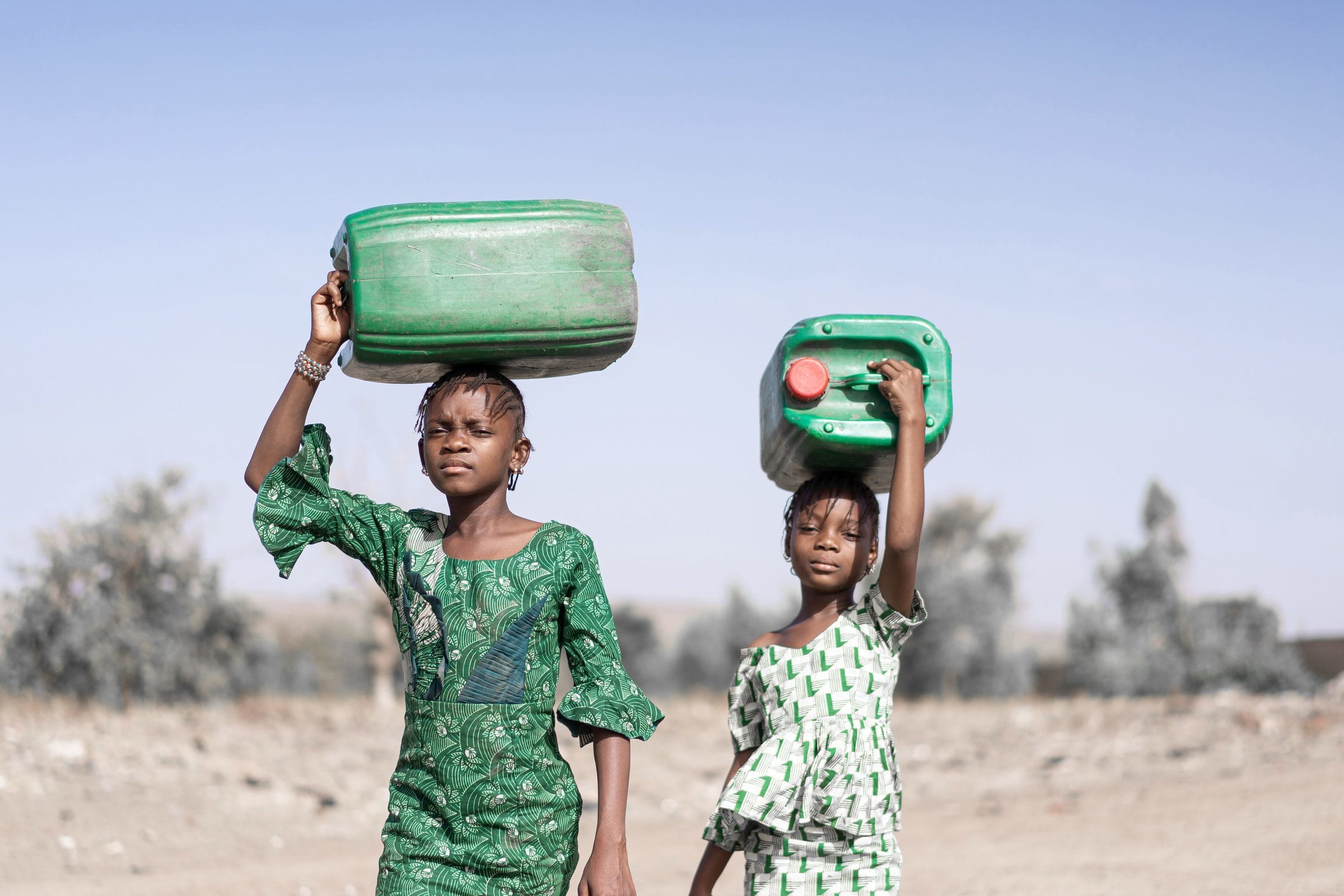Mädchen tragen Wasserkanister. (Foto: Shutterstock)